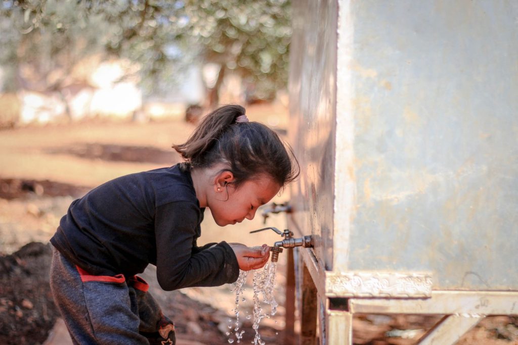 A children pouring fresh water in her hands